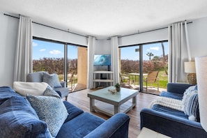 A modern living room with a TV, sofas, and a coffee table.