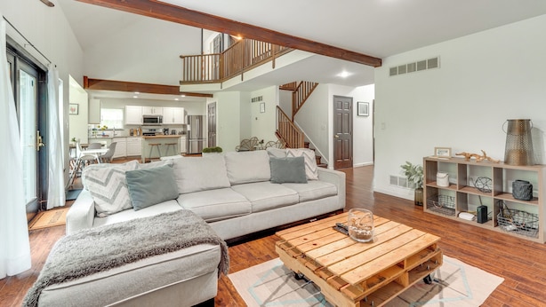 A spacious living area with a sofa, a coffee table, and a staircase leading to an upper level. - Family Home w/ Deck ~ 2 Mi to Camelback Mountain! (Tannersville)
