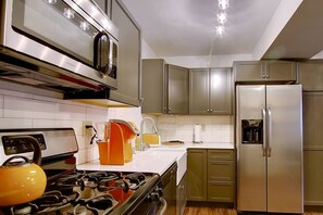 A modern kitchen with stainless steel appliances, a gas stove, and a built-in oven. - Remodeled TH Near Resort-Steps to Free Mtn/Town Bus Stop+ HotTub-W/D in Unit-Gas Fireplace-Mtn View (Steamboat Springs)