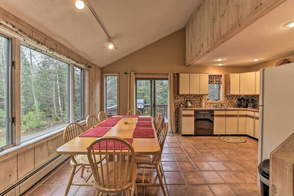 Enjoy meals in the kitchen with an oven and dining area featuring a long table and comfortable seating.