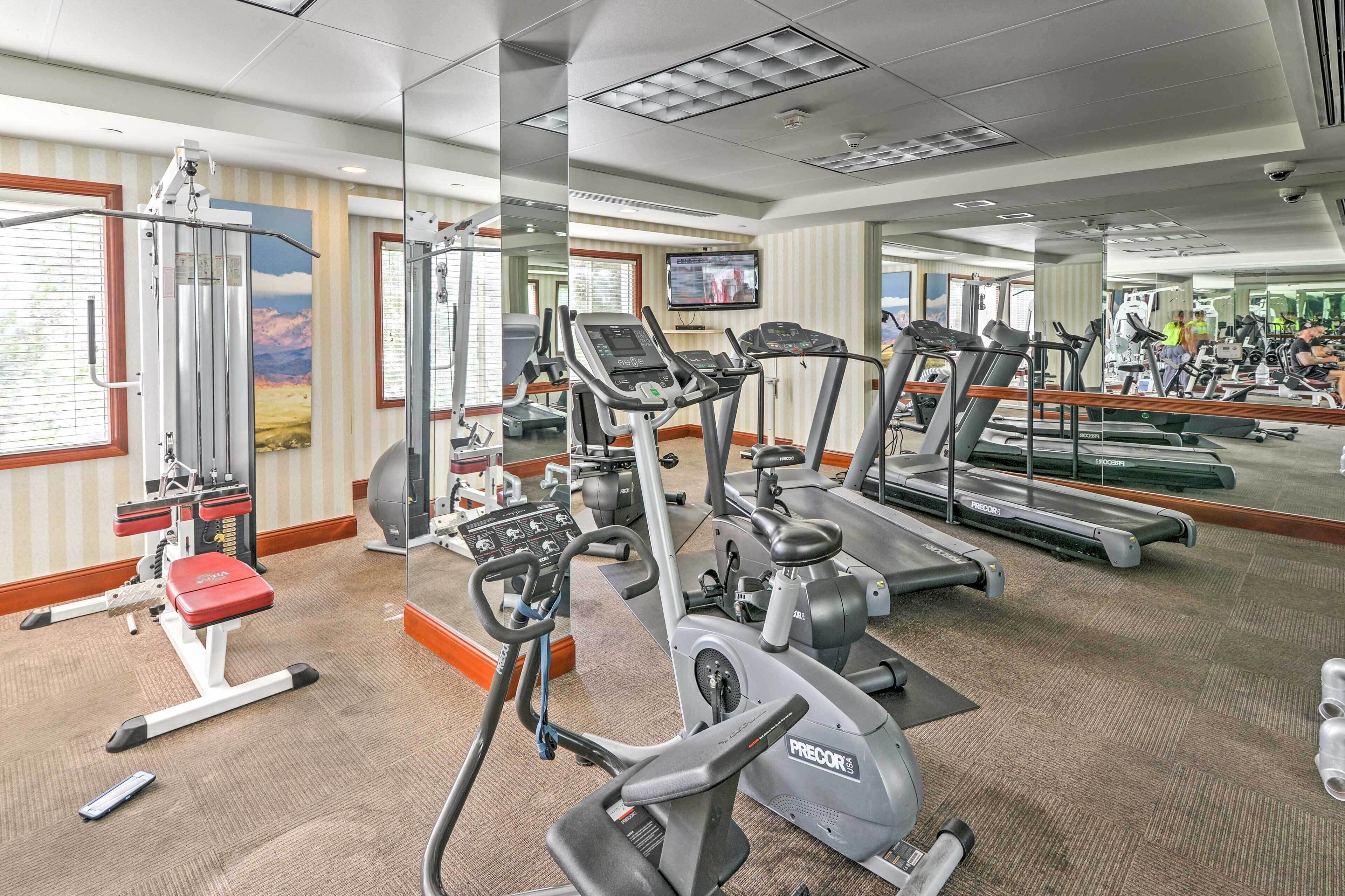 Ein Fitnessstudio mit Laufbändern, Crosstrainern und Kraftgeräten.