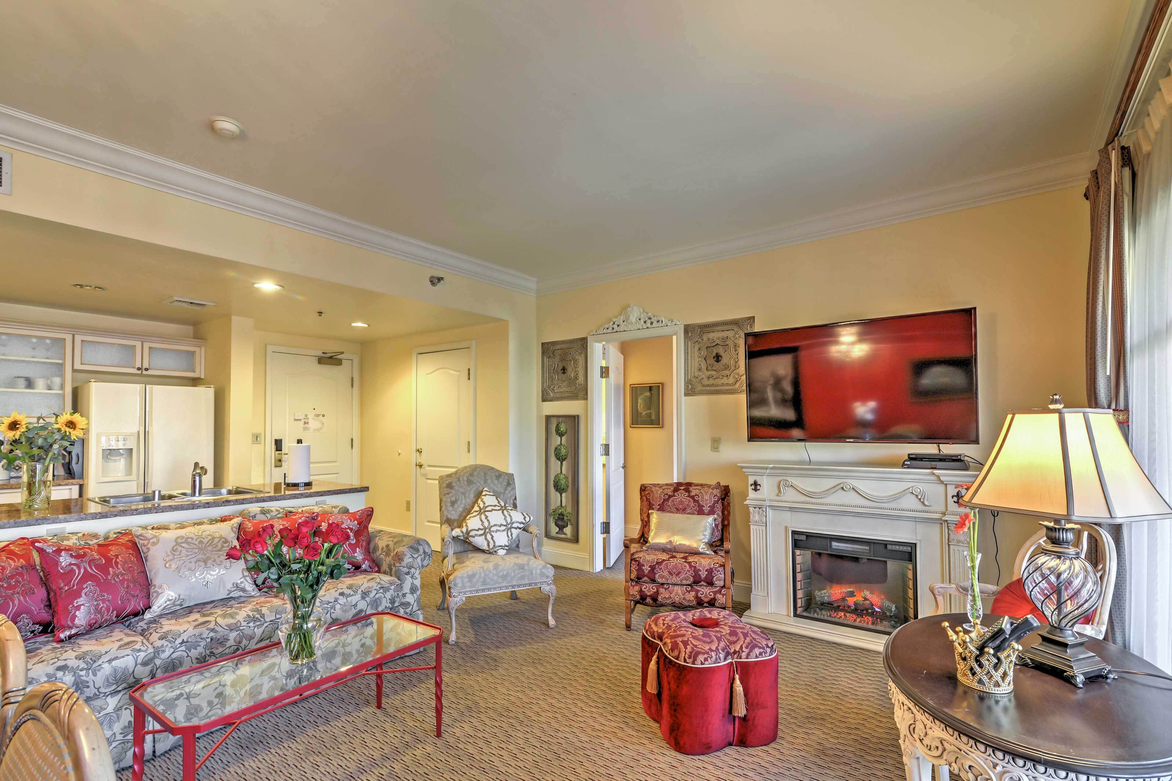 Una sala de estar con sofá, sillones, chimenea y televisor.