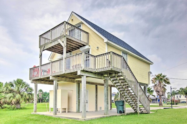 A two-story house with a balcony and a staircase leading to a second floor. - < 1 Mi to Beach! Waterfront Galveston Bay Retreat (Galveston)
