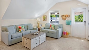 A cozy living room with two light blue sofas, a wooden coffee table, and a white side table. - **SUZY'S PARROT PERCH @ OLD TOWN** Condo + Last Key White Glove Service... (Key West)