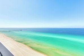 A beach with clear turquoise water and a long pier extending into the sea. - Panama City Beachfront Condo w/ Breathtaking Views (Panama City Beach)