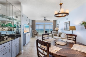 Enjoy meals in the dining area with a wooden table and chairs, and take in the view from the large window.