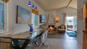 A spacious living room with a fireplace, modern furniture, and artwork on the walls. - Beautiful newly remodeled upper unit located within the first block to beach! (Newport Beach)