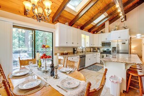 Enjoy cooking in this well-equipped kitchen with a central island and large window offering a view of the surrounding forest.