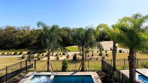 Zona de piscina con vistas despejadas del paisaje circundante, que incluye un campo de golf y varios árboles.