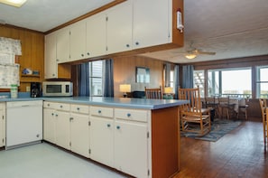 Enjoy meals in the kitchen with a central island, microwave, and dishwasher, and dine in the adjacent dining area with a table and chairs.