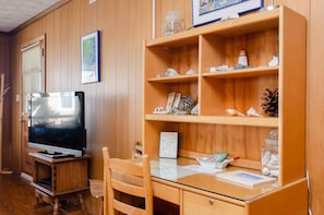Relax in this inviting space with a large flat-screen TV, comfortable chair, and plenty of natural light.