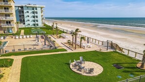 Un hôtel doté d’une piscine, de chaises longues et offrant une vue sur la plage.