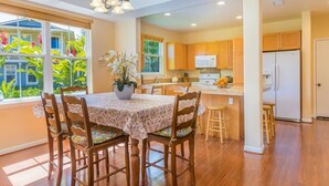 A spacious kitchen with wooden cabinets, a central island, and a dining area with a table and chairs. - Amazing private home with AC, Pool, Garage, Hot Tub and Toys N27C (Princeville)