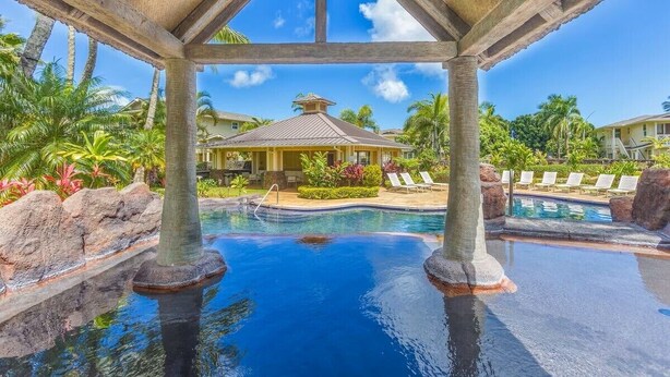 A resort pool area with clear blue water, palm trees, and lounge chairs. - Amazing private home with AC, Pool, Garage, Hot Tub and Toys N27C (Princeville)
