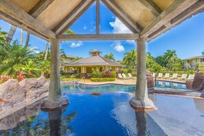 A resort pool area with clear blue water, palm trees, and lounge chairs. - Amazing private home with AC, Pool, Garage, Hot Tub and Toys N27C (Princeville)