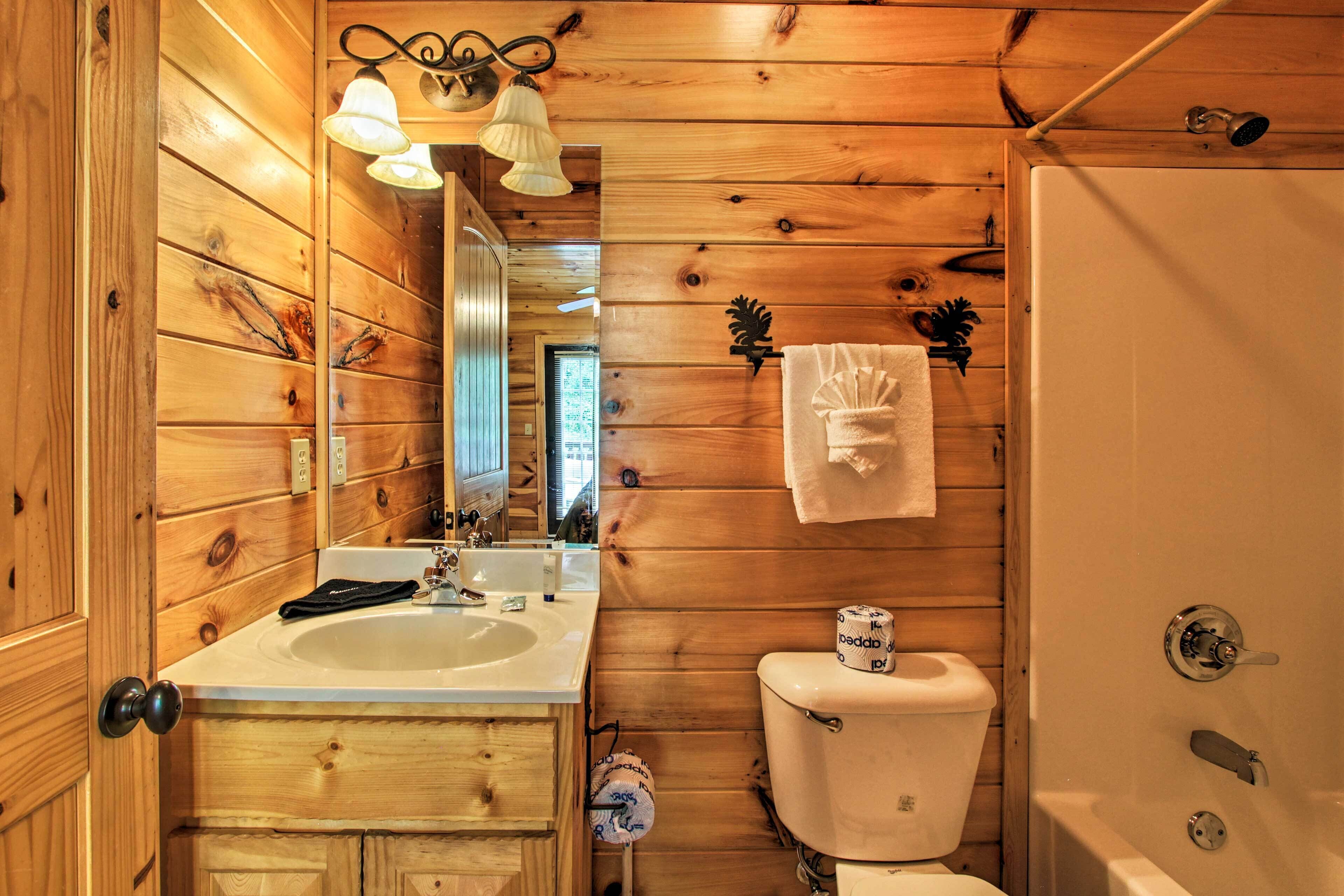 Bagno di una casetta di legno con lavandino, water e doccia.
