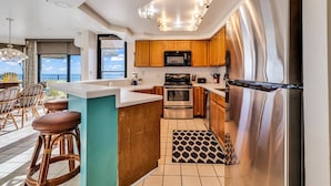 A modern kitchen with wooden cabinets, stainless steel appliances, and a large island. - *Fall into Savings-20% Off New Bookings thru 2026* (Garden City)
