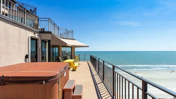 A balcony with a hot tub, yellow chairs, and a view of the beach. - *Fall into Savings-20% Off New Bookings thru 2026* (Garden City)