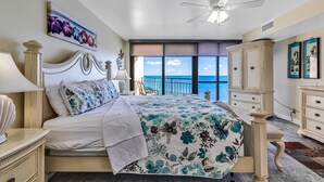 A bedroom with a large bed, a ceiling fan, a view of the sea, and a cabinet. - *Fall into Savings-20% Off New Bookings thru 2026* (Garden City)
