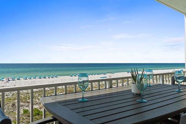 A balcony with a view of the beach and ocean.