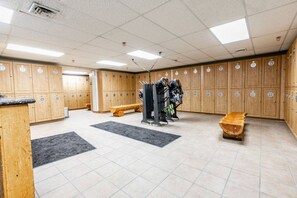 A locker room with multiple wooden lockers, a bench, and a shoe rack. - Westgate 4408 (Park City)