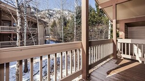 A wooden deck with a view of a mountain and trees.