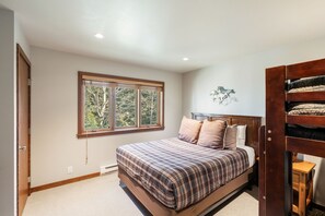 Une chambre à coucher avec un lit, une fenêtre, une tête de lit et une œuvre d’art accrochée au mur.