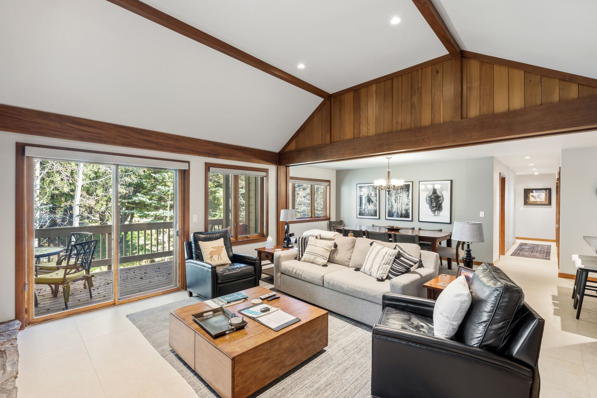 A spacious living room with a large sofa, a coffee table, and a dining area with a table and chairs.