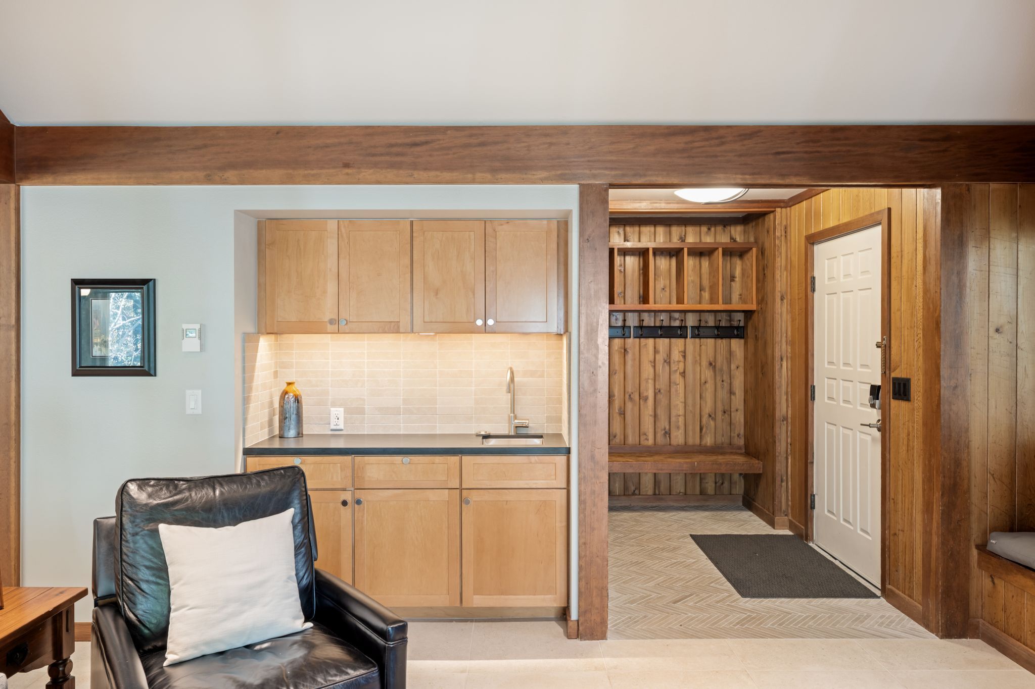 A compact kitchen with wooden cabinets, a sink, and a window.