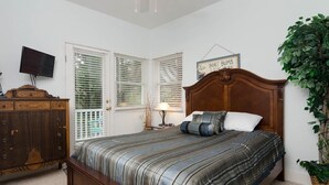 A bedroom with a wooden bed, a television on the wall, and a sign above the bed. - Charming 3 BR townhouse with sound views! (Wrightsville Beach)