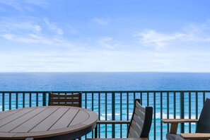 Enjoy the serene ocean views from this seaside terrace with a table and chairs.