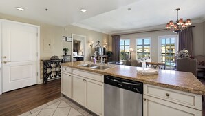 A spacious kitchen with granite countertops, stainless steel appliances, and a dining area with a chandelier.