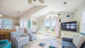 A spacious living room with a large TV, comfortable seating, and a view of the outdoors. - Bali Hai - Kitty Hawk MP 3, 50 Yards to Beach, Breathtaking Views, Open Decks (Kitty Hawk)