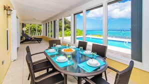 A dining area with a view of a swimming pool and ocean. - Thatch Hill: Beach House w/ Private Pool & Backyard Snorkeling, Walk to the Rum Point Club! (Grand Cayman)