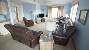 A living room with a sofa set, a TV, and a ceiling fan. - OS602- Private Pool, Hot Tub, WIFI, Oceanviews, Just Steps to the Beach! (Corolla)