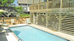A rectangular pool with a wooden fence and lounge chairs. - OS602- Private Pool, Hot Tub, WIFI, Oceanviews, Just Steps to the Beach! (Corolla)
