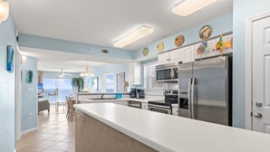A modern kitchen with a large island, stainless steel appliances, and decorative wall art.