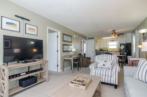 Relax in this open-plan living area with a TV, coffee table, and comfortable armchair.
