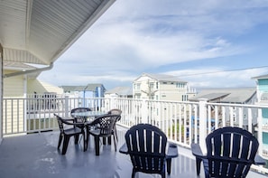 Enjoy the view from this balcony with a table and four chairs.