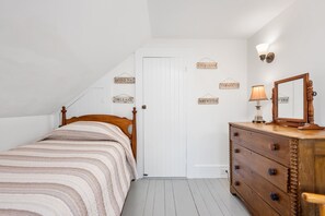 A bedroom with a bed, dresser, and wall-mounted signs.