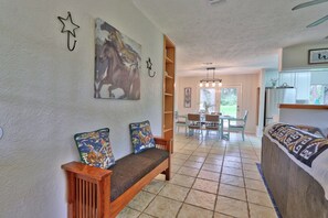A cozy living area with a wooden bench, a large horse painting, and a kitchen area with a refrigerator and cabinets. - Your own Private Oasis, pool, hot tub, fire pit on 10 gorgeous acres (Wimberley)