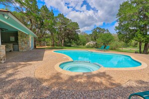 A swimming pool with a stone deck, a covered patio, and a stone building with a sign. - Your own Private Oasis, pool, hot tub, fire pit on 10 gorgeous acres (Wimberley)