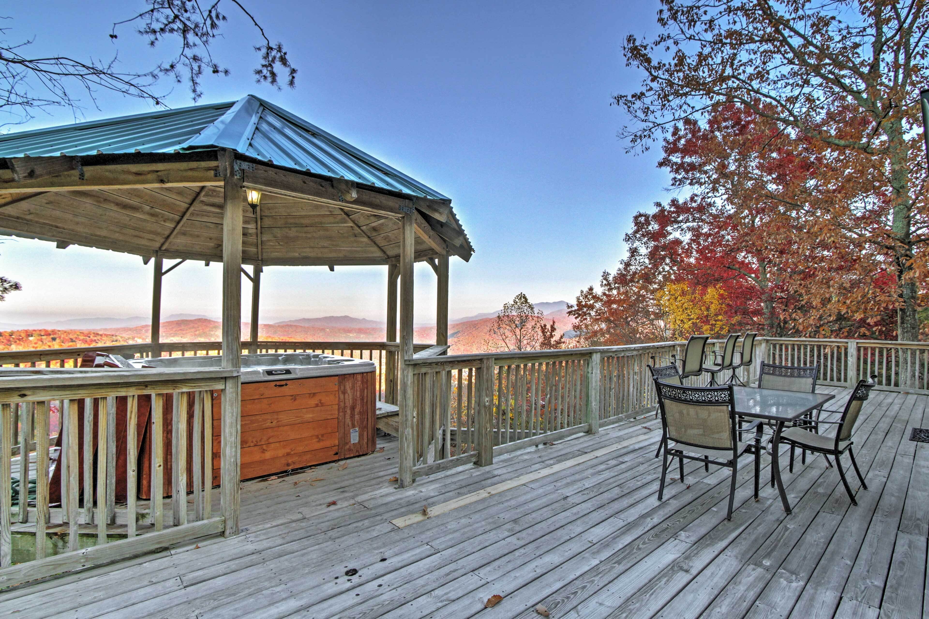 A wooden deck with a covered seating area and a hot tub.