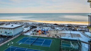A tennis court with a view of the beach and a playground with slides. - Charming, unique 2-bedroom oceanfront condo with southwest decor, free WiFi, an indoor and outdoor pool, and more located uptown just steps from the beach! (Ocean City)