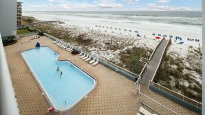 Et poolområde med udsigt over stranden og havet.