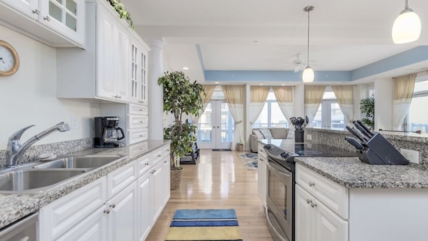 A modern kitchen with white cabinets, granite countertops, and a central island. - Unique 5BR, 4.5 bath single floor condominium with great ocean views. (Ocean City)