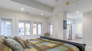 A bedroom with a large bed, multiple windows, and a view of the outside. - Unique 5BR, 4.5 bath single floor condominium with great ocean views. (Ocean City)