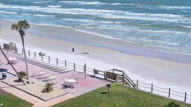 Un hôtel situé en bord de mer, doté d’un patio, de coins salon extérieurs et offrant une vue sur l’océan.