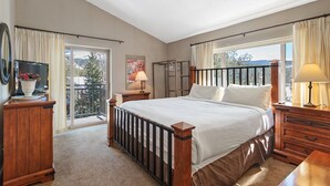 Ein Schlafzimmer mit einem großen Bett, einem Fernseher, einer Lampe und einem Kleiderschrank.