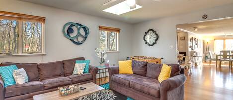 A spacious living room with two brown leather sofas, a wooden coffee table, and a patterned rug.